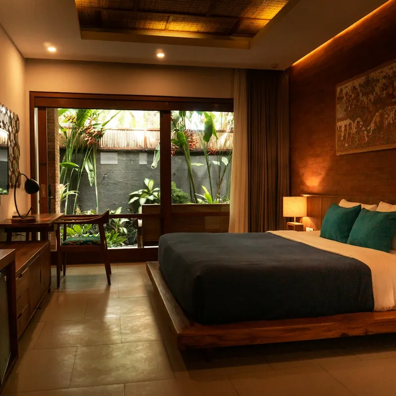 The Lantern Suite bedroom with ocean-facing windows at golden hour